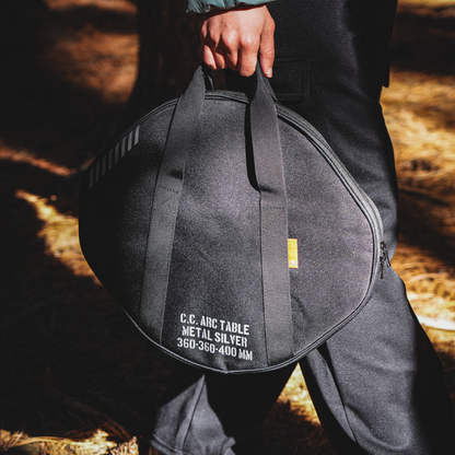 Portable aluminum camping table packed in a carrying bag for travel