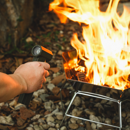 High-speed air blower stoking an established campfire with controlled airflow